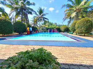 una grande piscina con palme sullo sfondo di Hotel Water Nest a Etagama