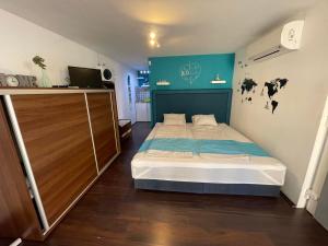 a bedroom with a bed and a blue wall at Smeraldo Home Fsz in Siófok