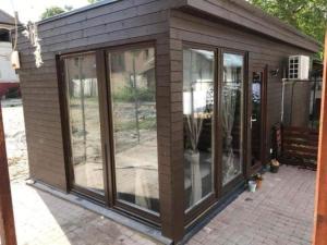 a small house with glass windows on a patio at Smeraldo Home Fsz in Siófok