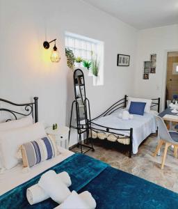 1 dormitorio con 2 camas, mesa y silla en DP Homes Studio Mimika Santorini en Perissa
