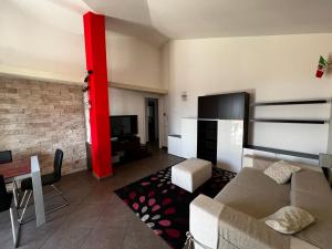 - un salon avec un canapé et une télévision dans l'établissement Attico con terrazzo, à San Costanzo