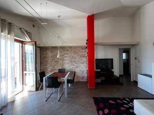une salle à manger avec un poteau rouge dans une pièce dans l'établissement Attico con terrazzo, à San Costanzo