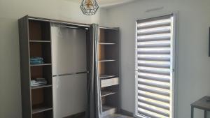 um armário com um frigorífico e uma janela em CHAMBRE MEUBLEE LIT 2 PERSONNES em Le Poiré-sur-Vie
