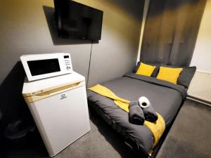 a small room with a bed with a tv on it at Stay Sleep Rest - De Grey in Hull