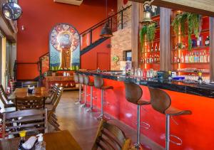 a restaurant with a bar with wooden tables and chairs at Matiz Vilaboim Ribeirão Preto in Ribeirão Preto