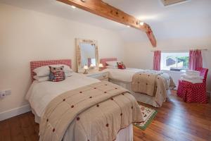 1 dormitorio con 2 camas y espejo en Well House, en Cornhill-on-tweed