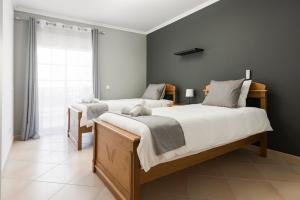 奎特里拉的住宿－Roberto Quarteira Central，一间卧室设有两张床和窗户。