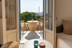 una camera con porta che si apre su un patio con tavolo di Queen bee seafront a Kampos Paros