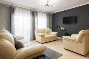 奎特里拉的住宿－Roberto Quarteira Central，客厅配有两把椅子和电视