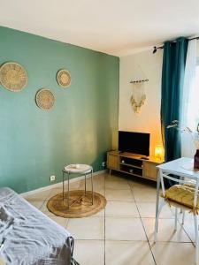 a room with a bed and a table and a tv at Le Studio Cosy *Place du village in Les Salles-sur-Verdon