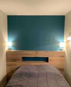una cama en una habitación con una pared azul en Appartement vue Mer à Porticcio, en Porticcio