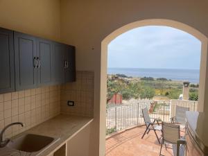 a kitchen with a view of the ocean from a balcony at A Casa di Amy 2.0 in Macari +4 photos