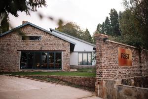 a brick building with a post sign on a brick wall at Rest Guesthouse in Dullstroom