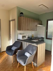 a kitchen with two chairs and a microwave at Mooie bungalow in de prachtige natuur in Hastière-par-delà