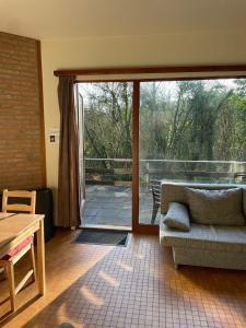 un soggiorno con divano e una grande porta scorrevole in vetro di Mooie bungalow in de prachtige natuur a Hastière-par-delà