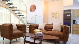 a living room with a couch and a table at Duplex Elegance Retreat Transit - 2 BR in Abu Dhabi