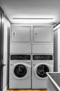 vier Waschmaschinen und Trockner, die in einer Küche übereinander gestapelt sind in der Unterkunft King Bed, Historic DTWN Hotel, Fiber Internet, Room # 404 in Bangor