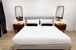 1 Schlafzimmer mit einem weißen Bett und 2 Spiegeln in der Unterkunft King Bed, Historic DTWN Hotel, Fiber Internet, Room # 404 in Bangor