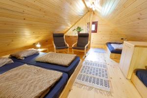 a room with two beds and two chairs in a log cabin at Bomas house in Cerkno