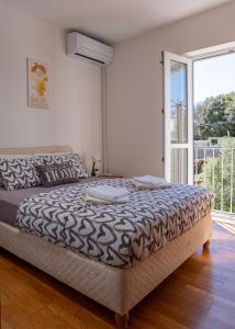 a bedroom with a bed and a large window at Dubrovnik Airport Apartment Tea in Durovići