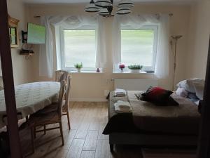 1 dormitorio con 2 camas, mesa y ventana en Apartament Kopernika, en Gdynia