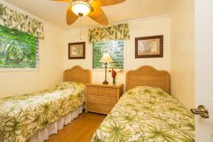 um quarto com 2 camas e uma ventoinha de tecto em Beachfront Villa - Garden View Home em Haleiwa