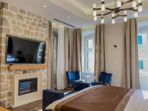 1 dormitorio con 1 cama grande y chimenea en Hive Luxury Suites by MN Property, en Kotor