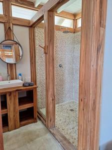 uma casa de banho com um chuveiro, um lavatório e um espelho. em Yothasse Makana Ponta Mamoli em Ponta Mamoli