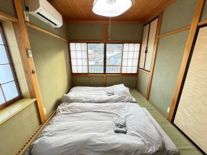 2 camas en una habitación pequeña con ventanas en Polar Resort Nikko 4 - Vacation STAY 30491v en Nikko