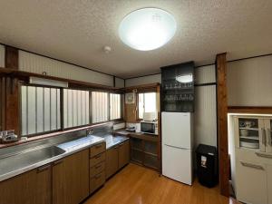 a kitchen with a white refrigerator and a sink at Polar Resort Nikko 4 - Vacation STAY 30491v in Nikko