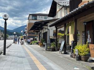 a street with buildings and people walking on the sidewalk at Polar Resort Nikko 4 - Vacation STAY 30491v in Nikko