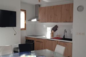 uma cozinha com armários de madeira e uma bancada em Appartement station Laye em Laye