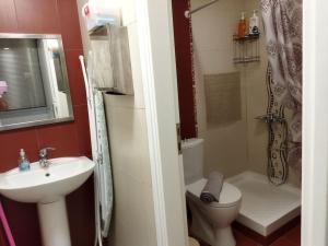 a small bathroom with a sink and a toilet at Cozy apartment near to the airport in Kouvarás