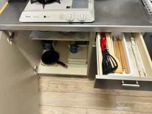 a drawer under a kitchen counter withtools under it at Rainbow takakura - Vacation STAY 16466 in Nagoya