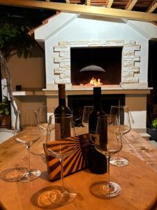 a table with three wine glasses and a fireplace at Kuća za odmor Antonini in Kaštela
