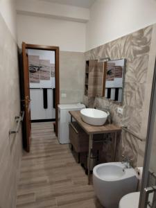 uma casa de banho com 2 lavatórios, um WC e um espelho. em Casa Sorelle Marchisio em Roma