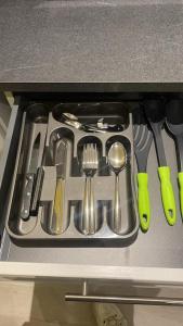 uma gaveta cheia de utensílios numa cozinha em L'Elégance 001 em Cambrai