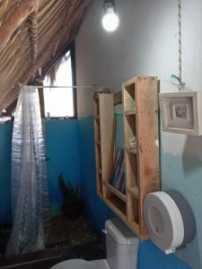 a bathroom with a toilet and a book shelf at El Puente in El Paredón Buena Vista