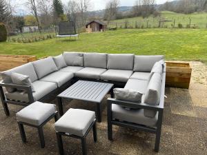 un canapé, deux chaises, une table et un champ dans l'établissement La Villa De Hauteville, à Hauteville-Lompnes