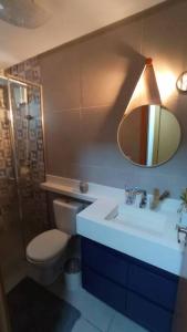 a bathroom with a sink and a toilet and a mirror at Apartamento em Uruguaiana in Uruguaiana