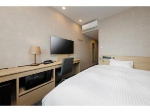 a hotel room with a bed and a flat screen tv at Soma Station Hotel - Vacation STAY 40250v in Soma +13 photos