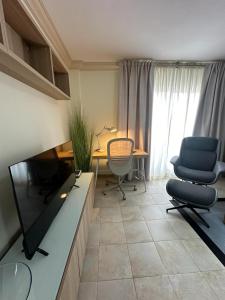 sala de estar con TV, 2 sillas y escritorio en Casa Adriana, en San Isidro