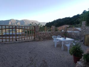 un patio con mesa, sillas y una valla en Casa/Cueva el Cigarrillo, en Pegalajar