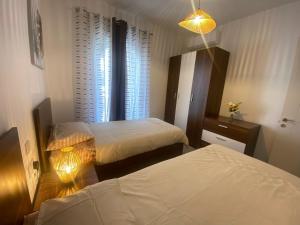 1 Schlafzimmer mit 2 Betten und einem Fenster in der Unterkunft Brand New 2 Bedroom Apartment in Tal-Pietà