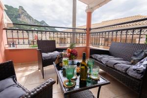 een balkon met een tafel met wijnflessen en glazen bij Almyra Apartments & Studios in Agios Gordios