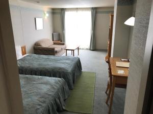 een hotelkamer met 2 bedden en een bank bij Furano Hops Hotel - Vacation STAY 41833v in Kami-furano