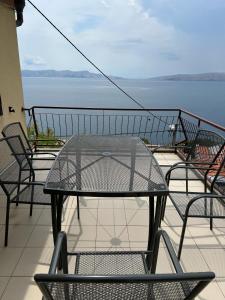 a table and chairs on a balcony with a view of the water at Apartment Ivanka in Senj