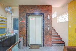 un pasillo con una puerta en un edificio con escaleras en OYO Hotel Sahara Residency, en Narasimharaja Puram