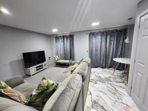 uma sala de estar com um sofá e uma televisão de ecrã plano em Sixty Nines em Dallington