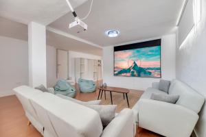 ein Wohnzimmer mit weißen Möbeln und einem Gemälde an der Wand in der Unterkunft VACATION MARBELLA I Sunny Camelia Villa Heated pool in Benalmádena